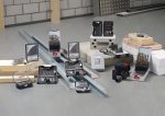 Verschiedene Bohrer- und Bohrersets sind in einer Werkstattumgebung auf Baumaterialien angeordnet.